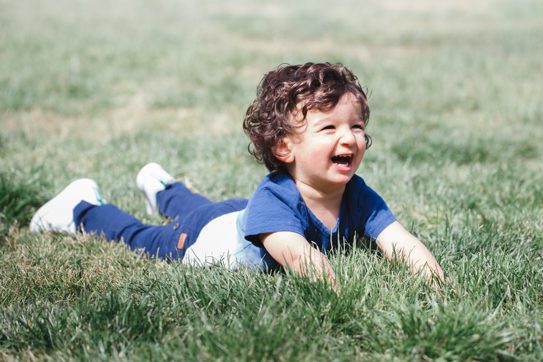 Picture of a Toddler boy laughing. Outdoor portrait photography, fun, lifestyle photo session at the park in Berkeley, California. 
